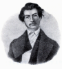 man in suit, head slightly tilted, facial hair